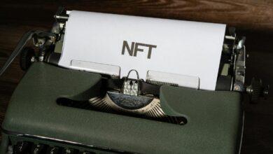 Close-up of a vintage typewriter with the word 'NFT' typed on paper, symbolizing digital innovation.