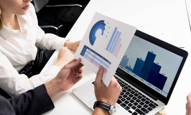 Business professionals discussing data charts and graphs in a modern office setting.