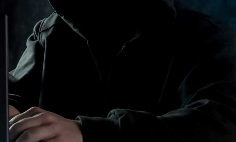 a man in a hoodie using a laptop computer