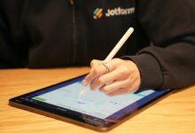 a person writing on a tablet with a pen