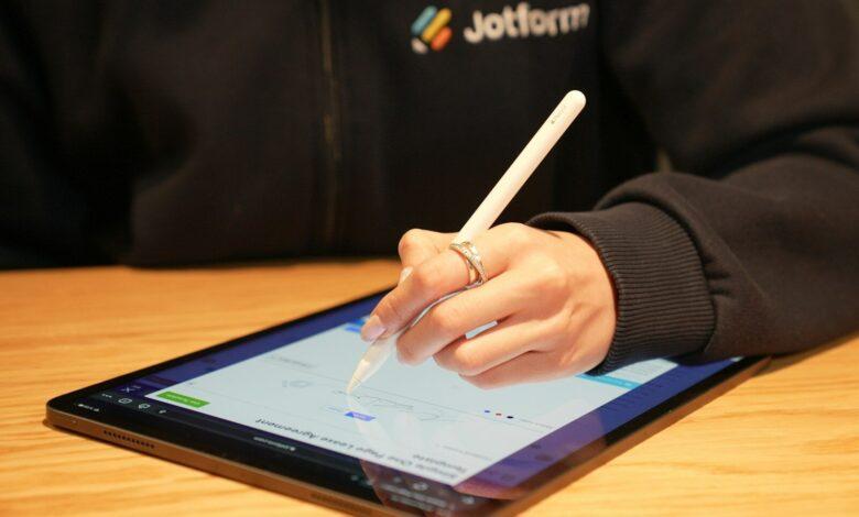 a person writing on a tablet with a pen
