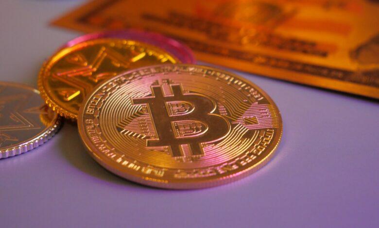 Golden bitcoin coin with other coins and card.