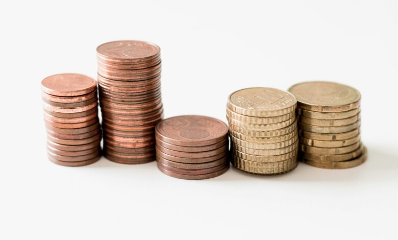 stacked round gold-colored coins on white surface