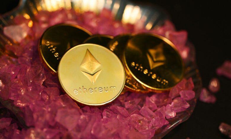 two gold coin sitting on top of a pile of pink crystals
